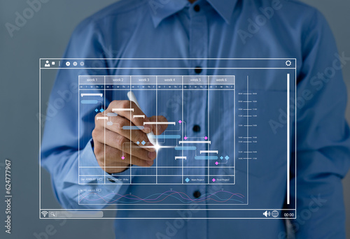 Project manager working with Gantt chart schedule to plan tasks and deliverables. Corporate strategy for finance, Scheduling activities with a planning software, operations, sales, marketing..