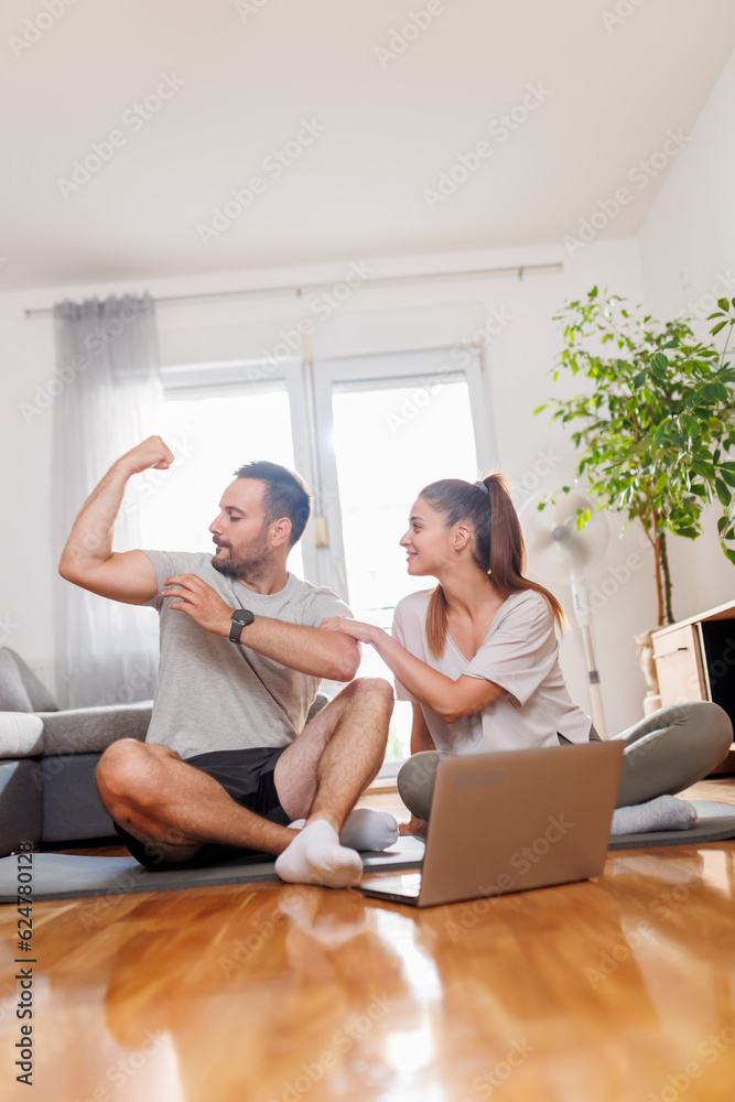 Couple taking a break while doing online home workout
