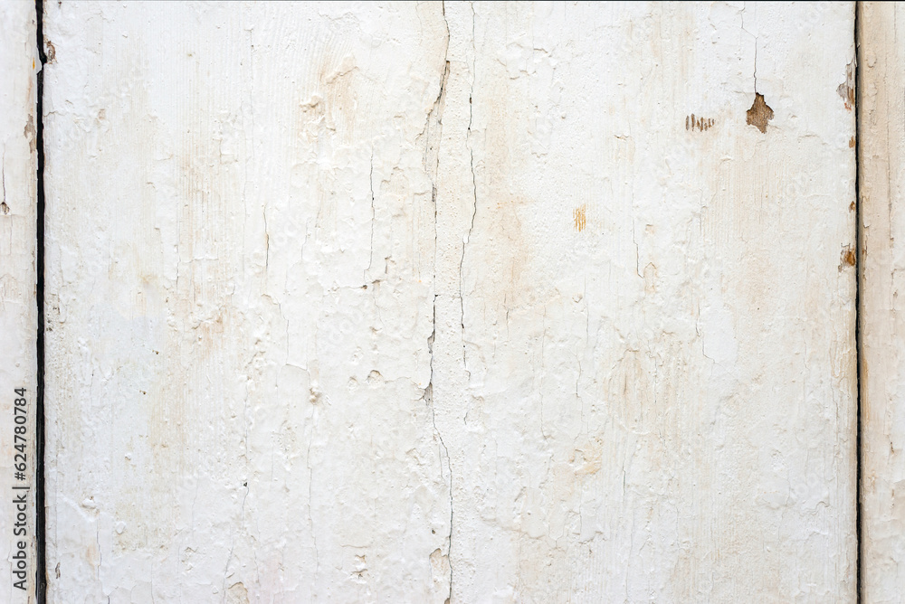 Close up photo of a wooden plank covered with white old cracked paint. Abstract background