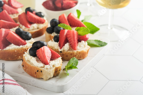 American flag sandwich with strawberries  blueberries  whipped sweet cream  soft cheese on toast bread. 4th of July American Independence Day food. Independence or Patriotic Day breakfast idea Mock up