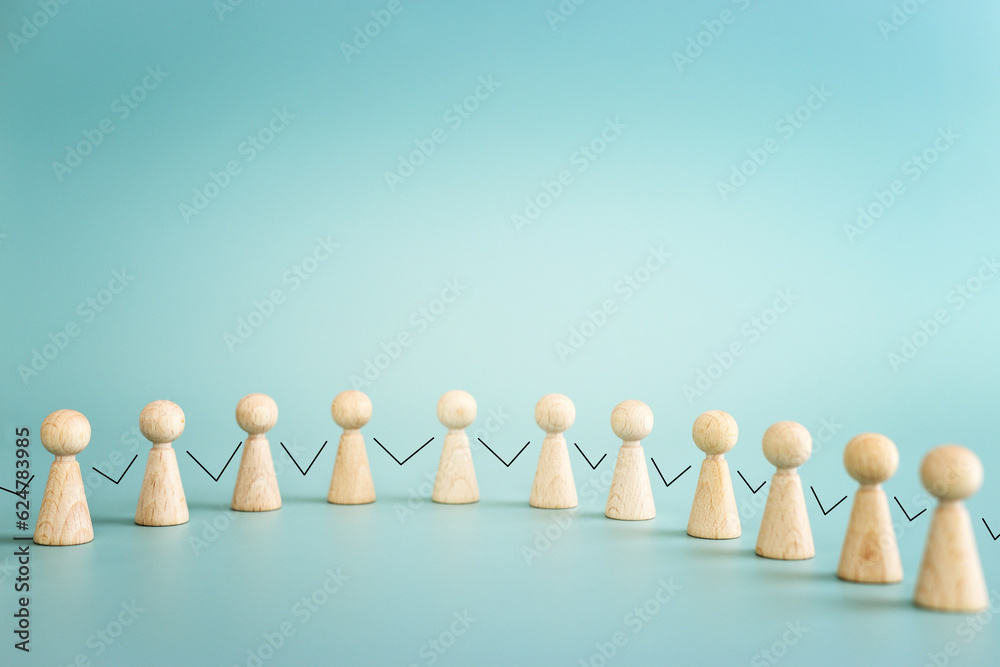 Concept image of wooden figures holding hands. An idea of unity, cooperation and success Concept image of wooden figures holding hands. An idea of unity, cooperation and success