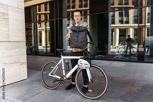 The courier is a man delivering a food order to the office, opens the bag and takes out the order. The cyclist is an employee of the courier company.