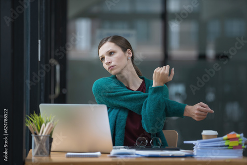 Beautiful businesswoman stretching hands in office.