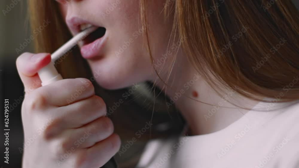 Young woman using remedy for sore throat closeup Young woman using remedy for sore throat closeup