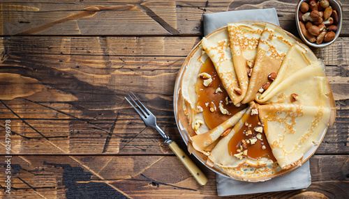 Foto crepes with salted caramel and nuts, top view, wooden background, copy space