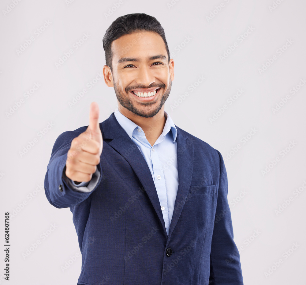 Happy businessman, portrait and thumbs up for success, approval or winning against a grey studio background. Asian man smile with like emoji, yes sign or good job for business agreement and thank you Happy businessman, portrait and thumbs up for success, approval or winning against a grey studio background. Asian man smile with like emoji, yes sign or good job for business agreement and thank you