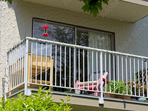 Residential balcony of an apartment building with hummingbird feeder