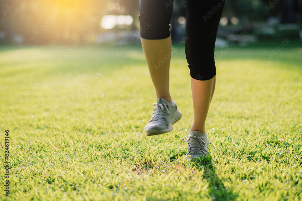 Embrace the concept of wellness living. Witness the close-up of a female jogger's legs and shoes as she runs during sunset in a public park. Embrace the concept of wellness living. Witness the close-up of a female jogger's legs and shoes as she runs during sunset in a public park.