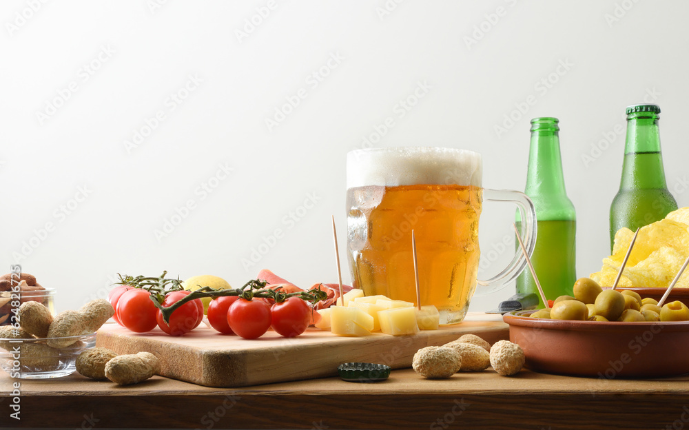 Various snacks on wooden table with beer mug isolated white Various snacks on wooden table with beer mug isolated white