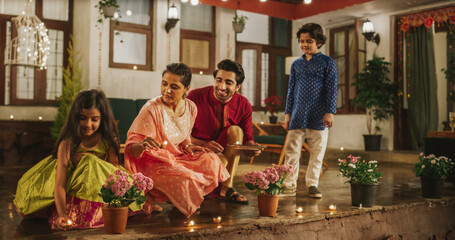 Portrait of an Indian Family Celebrating Divali by Putting Lamps in Their Backyard. Happy Young Parents and Their Exited Children Participating in Hindu Religious Festivities, Festival of Lights