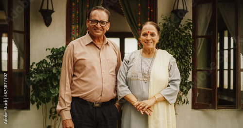 Portrait of Happy Indian Elderly Couple Posing Together at Their Authentic Mumbai Home. Senior Husband and Wife Celebrating Shared Years of Love and Appreciation, Looking at the Camera © Kitreel