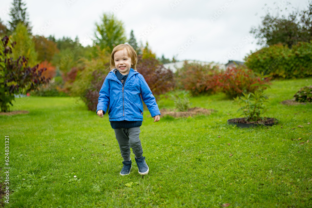 Funny toddler boy having fun outdoors on sunny autumn day. Child exploring nature. Kid playing in a city park. Autumn activities for kids. Funny toddler boy having fun outdoors on sunny autumn day. Child exploring nature. Kid playing in a city park. Autumn activities for kids.