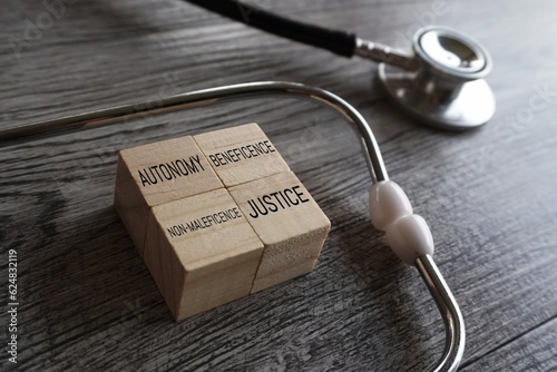 фотографія Stethoscope and wooden cubes with text AUTONOMY, BENEFICENCE, NON-MALEFICENCE, and JUSTICE