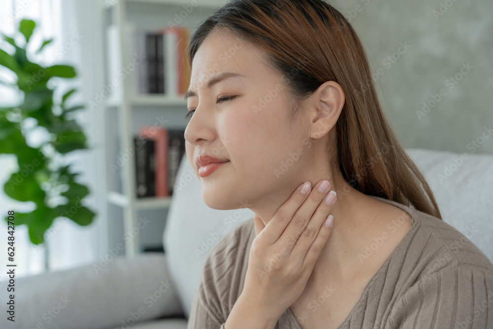 Aisa woman put her hand on her neck due to a sore throat. female tonsillitis causes a inflammation. treated by taking water, taking antibiotics, consult a doctor, virus, corona virus, Influenza, flu Aisa woman put her hand on her neck due to a sore throat. female tonsillitis causes a inflammation. treated by taking water, taking antibiotics, consult a doctor, virus, corona virus, Influenza, flu