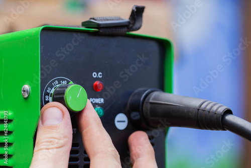 Adjusting the current strength on a modern welding machine. Welding arc. Close-up photo