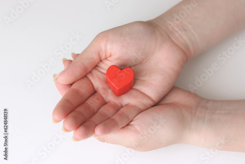 Hands holding red heart, healthcare, love, organ donation, mindfulness, wellbeing, family insurance and CSR concept, world heart day, world day