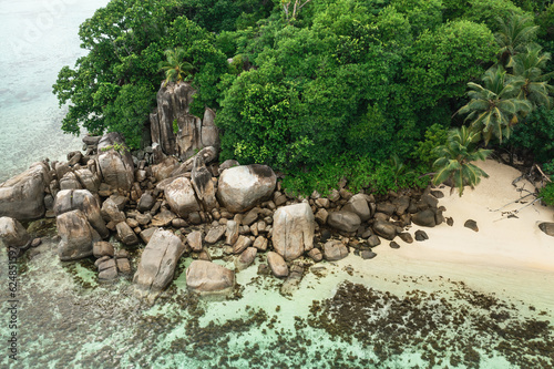 Scenic beach with granite rocks and palm trees at Seychelles, Mahe Island
