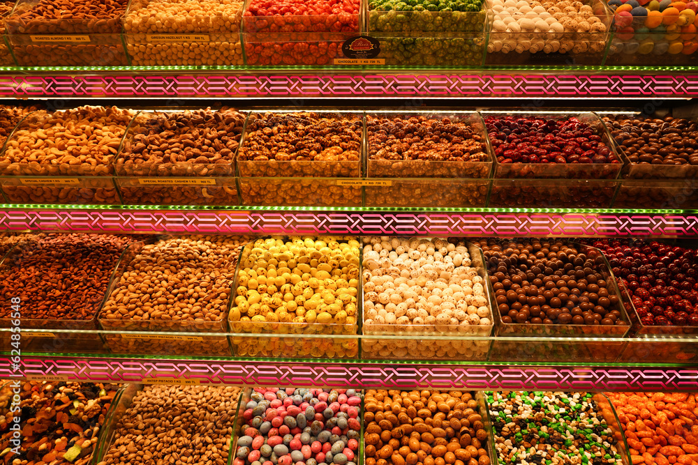 Piles of sweets chocolate, dates, dried fruits, herbs, pastries and various other processed foods on display in a souvenir shop at a Turkish bazaar market