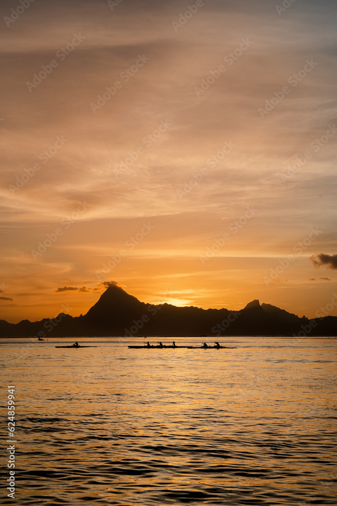 Fototapeta premium Atardecer isla de moorea en polynesia francesa y canoas remando horizonte 