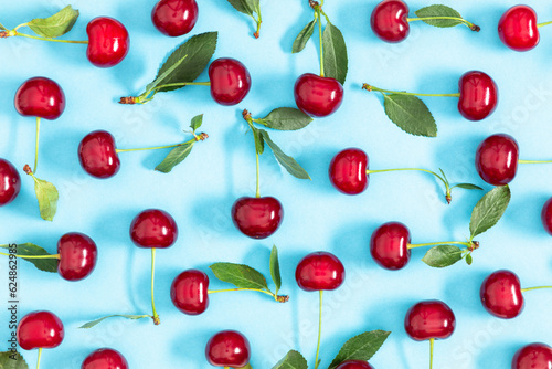Red cherry on blue background. Ripe red cherry berries as background. Flat lay, top view, copy space