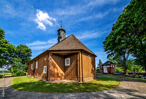General view and architectural details of the early 19th century brick chapel, wooden belfry and St. Roch Catholic Church in the village of Miłkowice Maćki in Podlasie, Poland.