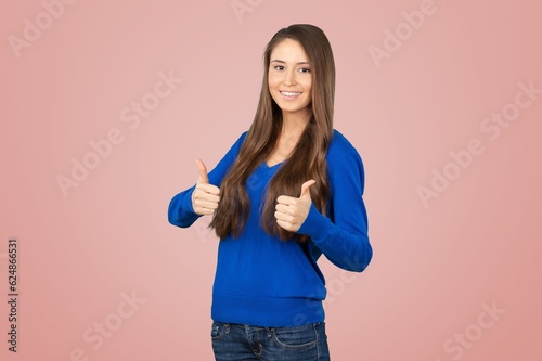 Portrait of happy young woman with thumb up posing