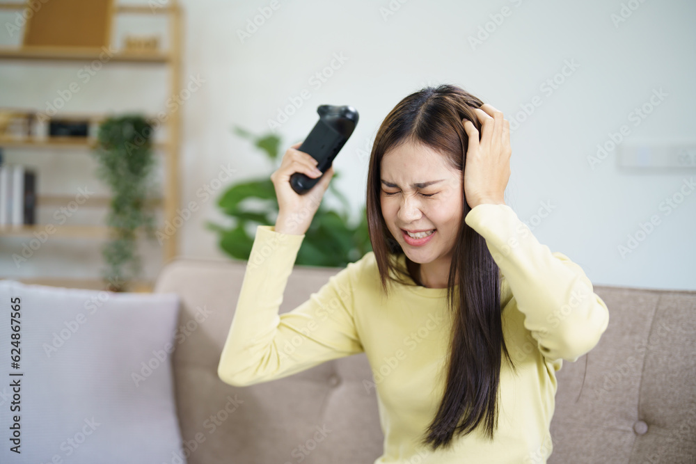 Upset Young Asian woman lose gamer controller video console playing holding hobby Online Video Game enjoyment eSport Cyber losing the game. Upset Young Asian woman lose gamer controller video console playing holding hobby Online Video Game enjoyment eSport Cyber losing the game.