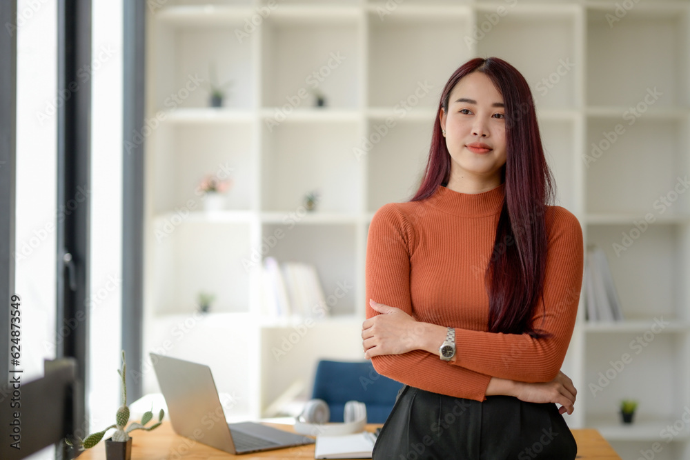 Portrait of young asian woman happy smiling with arms crossed standing in co-working space. Portrait of young asian woman happy smiling with arms crossed standing in co-working space.