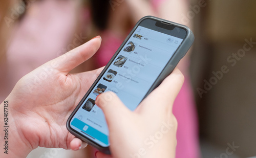 Close up of women hands using smart phone ordering food in soft focus