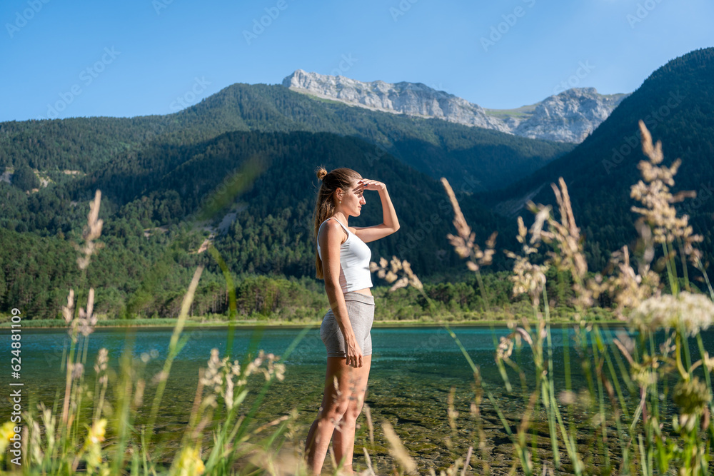 Naklejka premium A girl on a lake looking at the mountains.