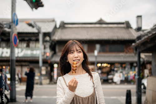 川越の観光地を食べ歩きをしながら散策する女性