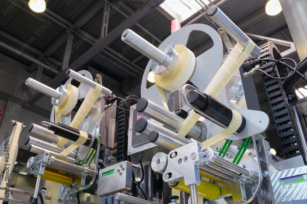 Fragment of the conveyor of sticking labeling machine. Abstract industrial background.