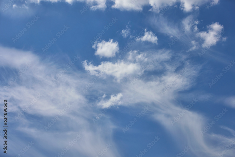 Cloudy blue sky background with white swirling clouds.