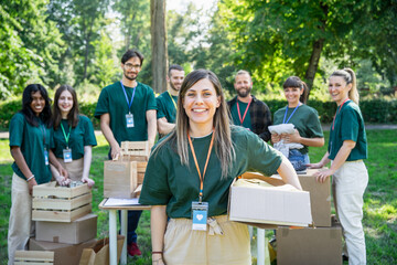 Portrait of a group of volunteers on a day of collection and distribution of clothes and food for people in need - Concept of solidarity and humanitarian aid - Copy space