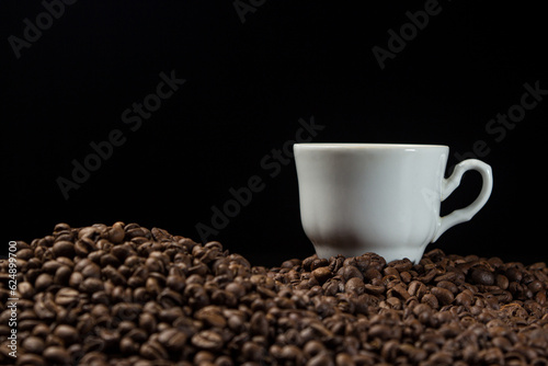A cup of espresso coffee on a background of coffee beans.
