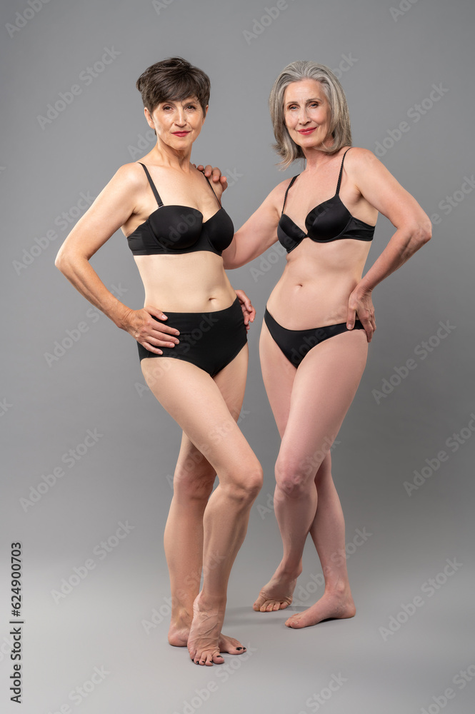 Senior women in black bra and panties standing close Senior women in black bra and panties standing close