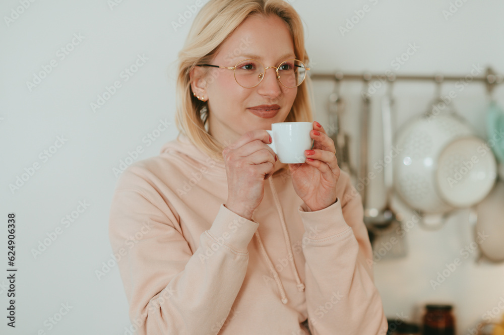 Portrait of a happy blond woman sipping a fresh cup of coffee at home. Portrait of a happy blond woman sipping a fresh cup of coffee at home.