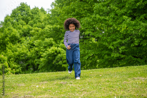 Fototapeta Naklejka Na Ścianę i Meble -  Curly-haired cute kid running and feeling excited