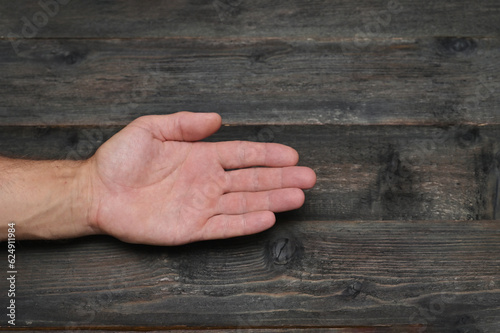 A man's palm on a background of wooden boards. hand close-up.