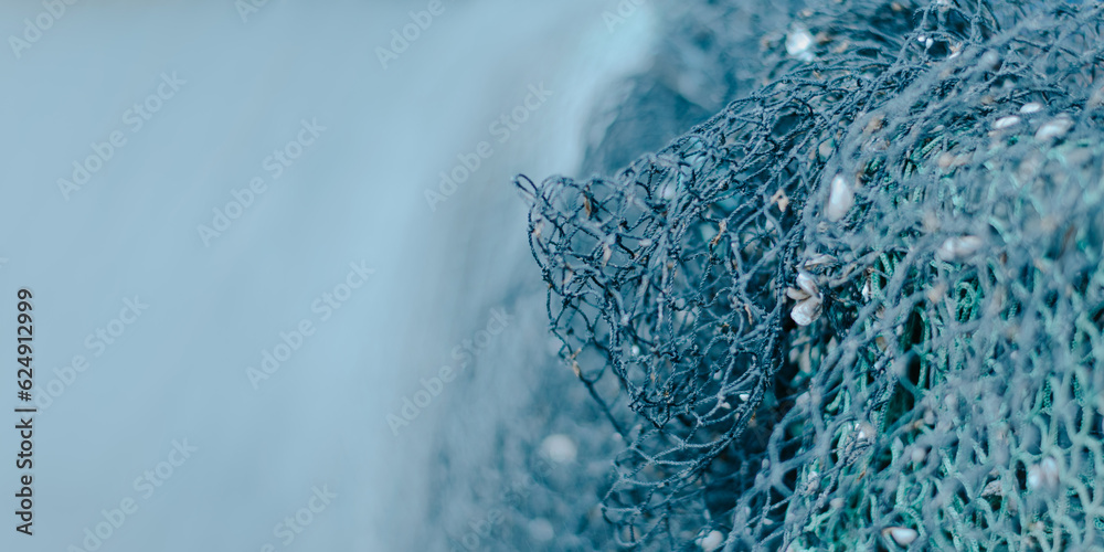blauer  Hintergrund mit viel Freifläche rechts ein Fischernetz schwache Schärfentiefe - obrazy, fototapety, plakaty 