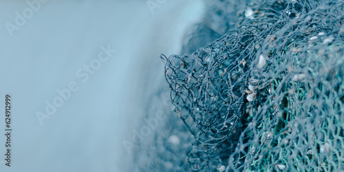 blauer  Hintergrund mit viel Freifläche rechts ein Fischernetz schwache Schärfentiefe