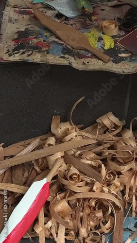 on the street man with beard of Indian appearance first people of Canada locals carving feather Poor people poverty close-up details of his work sawdust hands creativity crafting Vancouver Canada 2023 photo