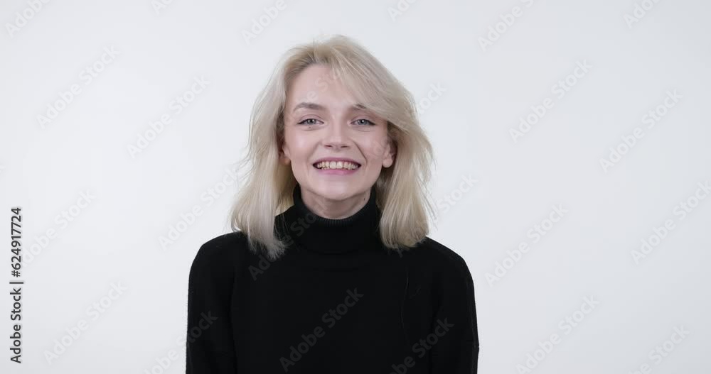 Woman stands against a white background, wearing a warm smile as she gazes directly into the camera. Suddenly she exclaims Wow in an enthusiastic manner. Woman stands against a white background, wearing a warm smile as she gazes directly into the camera. Suddenly she exclaims Wow in an enthusiastic manner.