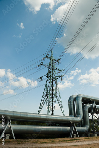 Fototapeta pipeline and power lines against the background of blue sky and clouds