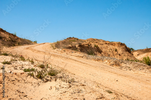 sand pit against the blue sky, forest in the background