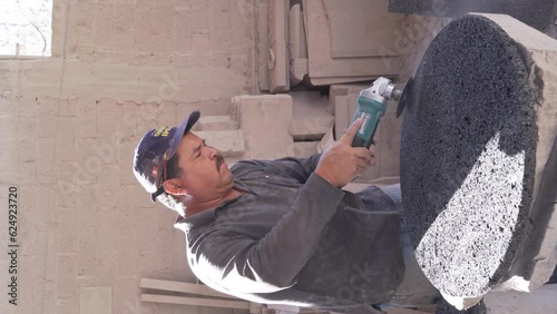large latino man, hand cutting stones in artisan quarry and marble workshop