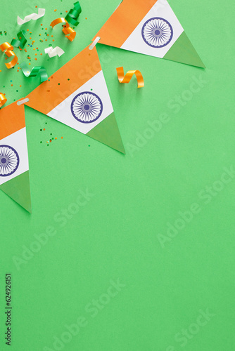 India Independence Day festive concept. Top view vertical composition of indian flag garlands, patriotic confetti on pastel green background with blank space for promo or text