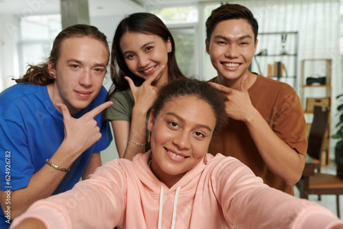 Diverse group of smiling teenagers taking selfie together