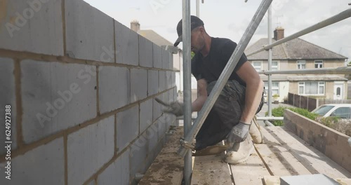Man pointing working with brickwork with scaffolding
