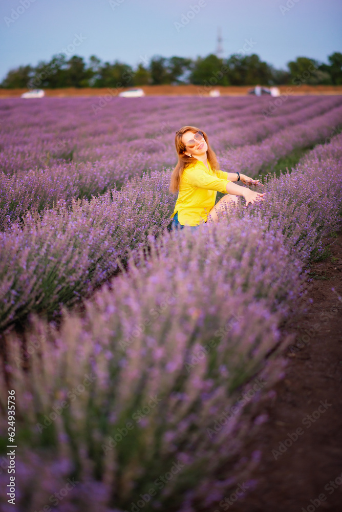 lavender field, a young woman in a yellow blouse and sunglasses walks in the field and smiles happily, summer july, lavender cultivation